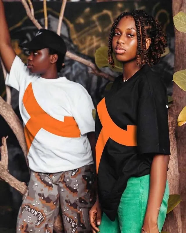 Deux mannequins portant le t-shirt au K orange de la collection 2026